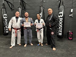 Het certificaat in ontvangst nemen van meesters Carlson Gracie Jr. en Marcos Flexa.